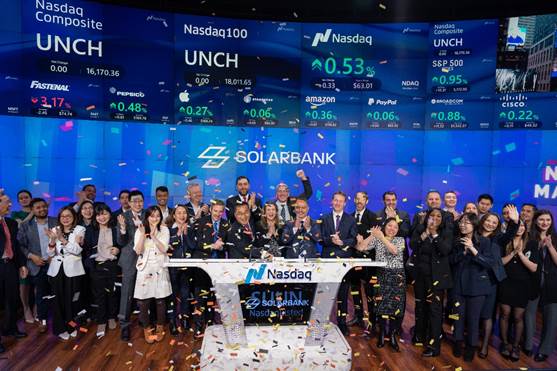 A group of people standing in front of a large screen with confetti

Description automatically generated