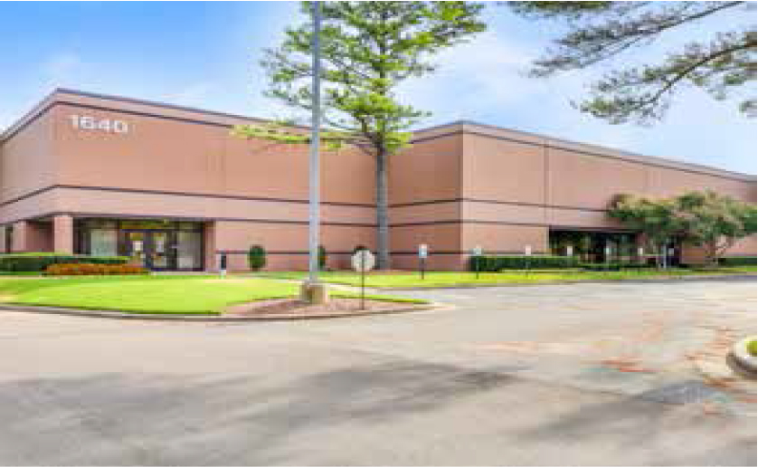 A building with a parking lot and grass

Description automatically generated