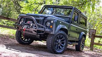 A black jeep parked on a dirt road

Description automatically generated